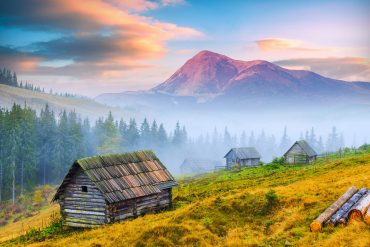old mountain cabins on a foggy hillside